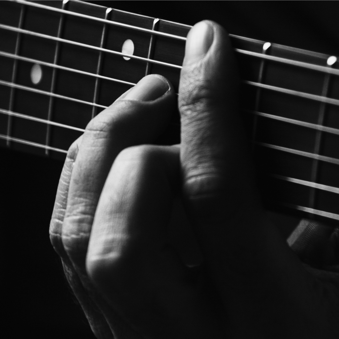 An example of a guitarist fretting a barre chord.